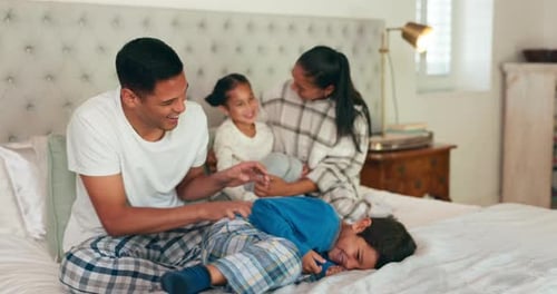 Family on Bed Tickling Son and Daughter