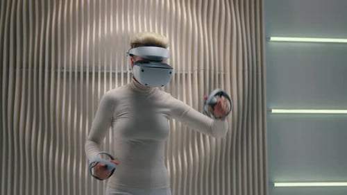 Woman Using Virtual Reality Headset with Handheld Controllers