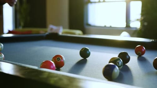 Colorful billiard balls arranged on a pool table during casual game night with friends