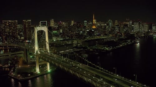 Helicopter view of the iconic rainbow bridge in Tokyo Japan at night with red camera