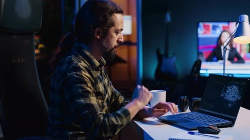Man Typing Code on Laptop Late at Night
