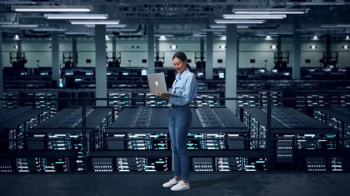 Side View Of Full Body Asian Business Woman Using Laptop Computer In Data Center