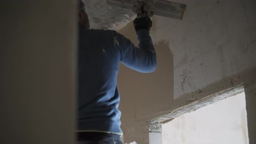 Construction Worker Applying Plaster to Interior Wall