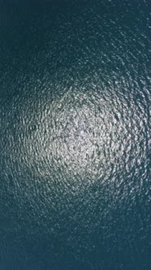 Vertical Aerial View on Sea Water Surface Camera Flies Over Clear Sea Water Sun Glare Abstract