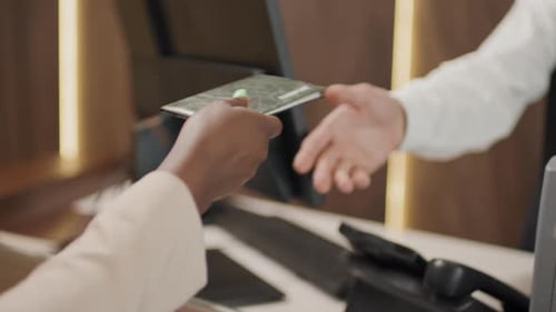 Unrecognizable Woman Passing Document To Hotel Receptionist