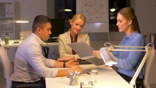Office Colleagues Collaborating on Project at Night