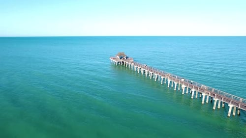 Aerial drone ascends over pier and waterfront homes in beautiful naples Florida