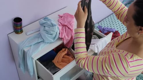 Woman Organizing Clothes in Bedroom Dresser