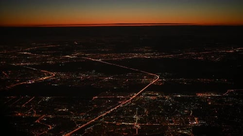 Aerial View of Night City Lights with Vivid Sunrise Sky
