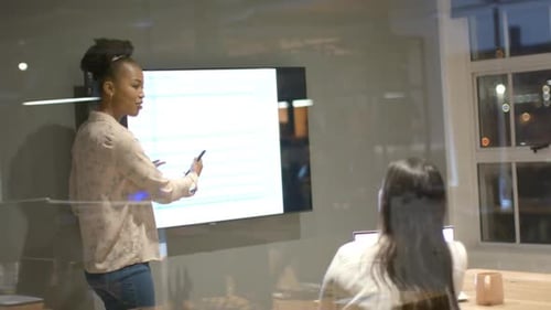 Young African American woman presents in a modern office setting