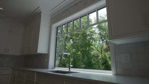 Modern Kitchen Interior with Window Overlooking Green Yard