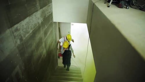 Construction Workers Walking Down Stairs with Equipment
