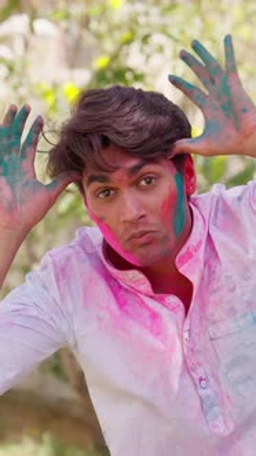 Happy Young Man Covered in Colorful Powder