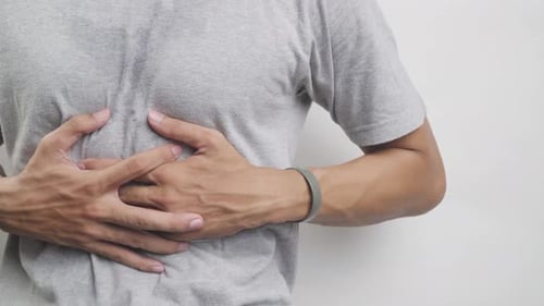 Adult Man Holding Chest in Apparent Pain