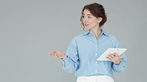 Managerin einer jungen Geschäftsfrau hält Präsentation an grauer Wand