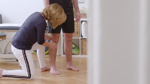 Medical Professional Examining Man's Leg in Clinic