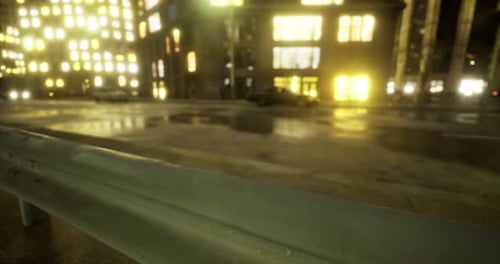 City Street at Night with Illuminated Buildings and Wet Pavement