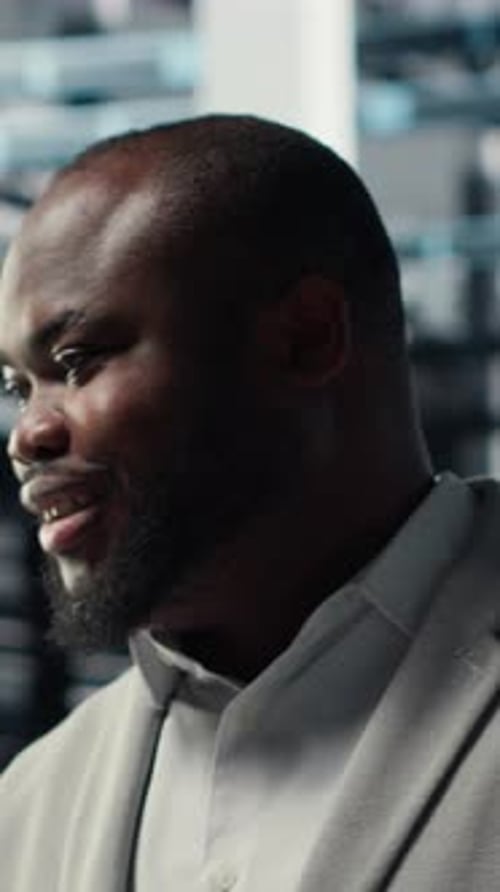 Vertical Video Smiling Server Room Engineer Performing Maintenance on Server Racks