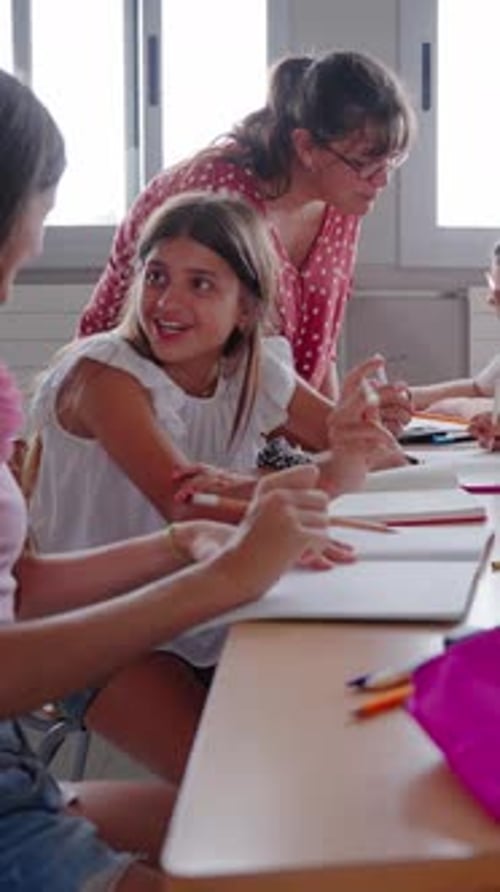 Female Primary School Teacher Explaining in Class to Diverse Group of Students