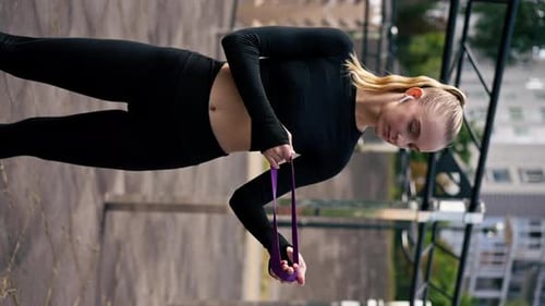 Close-up of a girl performing exercises with elastic bands to strengthen her arm muscles training