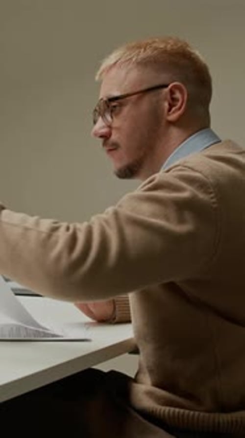 Male Manager in Wheelchair Passing Paper to Colleague Working at Desk in Office