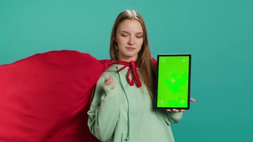 Woman Presents Tablet with Green Screen Wearing Cape