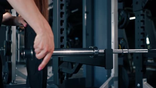 Der Nahaufnahme-Athletentrainer erhöht das Gewicht der Langhantel im Fitnessstudio und erhöht die Belastung des Körpers