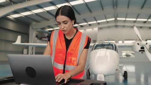 Aircraft Maintenance Engineer Working on Laptop in Hangar