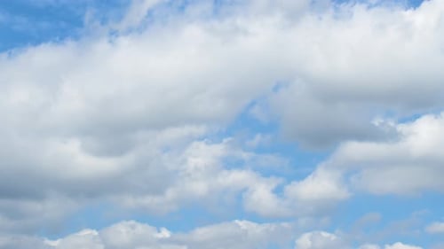 Fluffy White Clouds Drifting in a Sunny Blue Sky