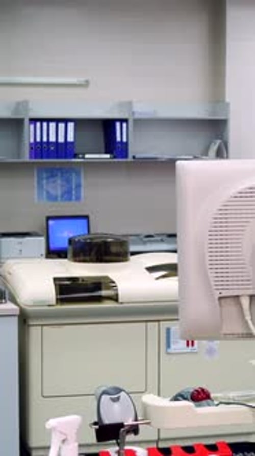 Male Lab Technician Walking By Medical Equipment