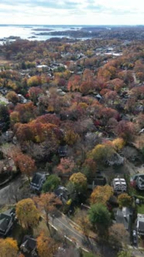 A smooth aerial circle around a residential property in Larchmont, NY, showing autumn trees, quiet