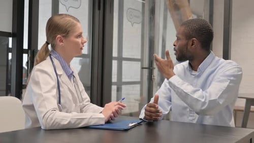 Doctor Consulting with Patient at Desk in Office