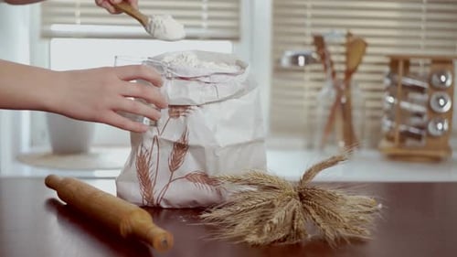 Home Baking Ingredients. Chef Puts Flour in Glass. Close Up Home Baking