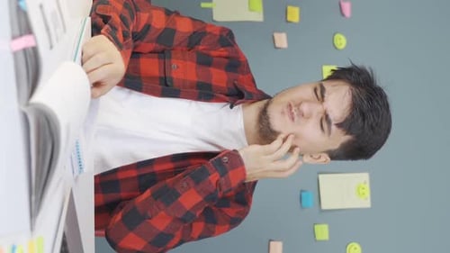 Young Man Writing and Suffering from Toothache