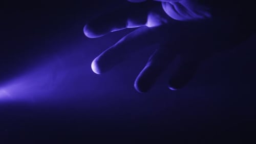 Hand Reaching in Mysterious Blue Lit Darkness