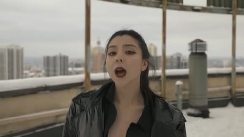 Woman in Leather Jacket Singing on Rooftop