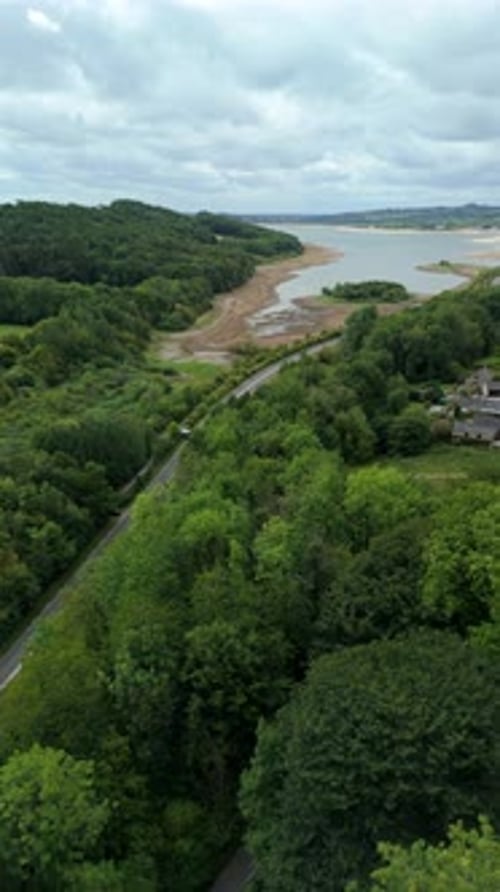 Aerial drone shot of Carsington Water reservoir, low water levels, and rural road with cars in