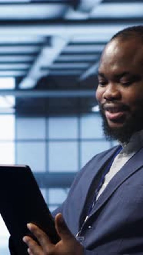 Man in Suit Uses Tablet in Workplace