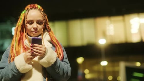 Woman with Colorful Hair Using Phone at Night