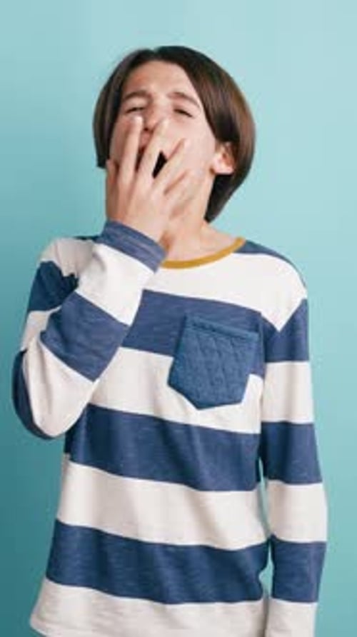 Sleepy Young Boy Yawning and Stretching in Studio Vertical