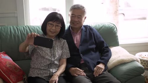 Senior couple in Canada capture happy memories with a sofa selfie at home