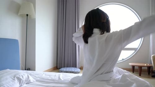 Asian woman waking up and sleep at morning in hotel room travel tourist concept