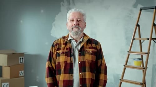 Man Smiles in Partially Painted Room