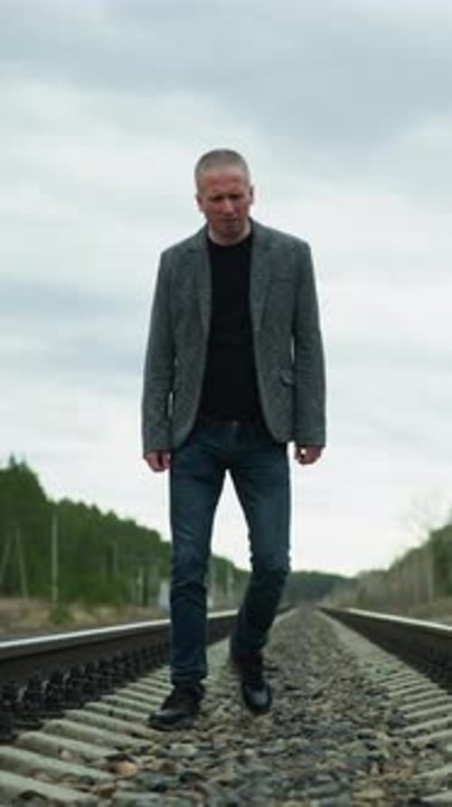 Man Walking on Railroad Tracks in the Countryside