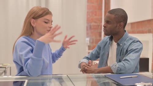 Couple interracial parlant assis à la maison