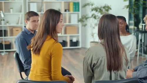 Group of People Sitting in a Circle Supporting Each Other During Group Therapy