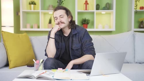 Hombre sentado solo en casa pensando en momentos felices y sonriendo.