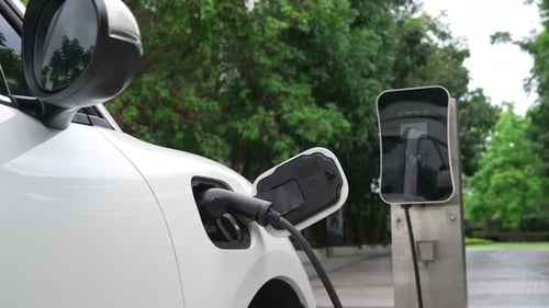 Progressive concept of electric car parking and recharging at charging station.