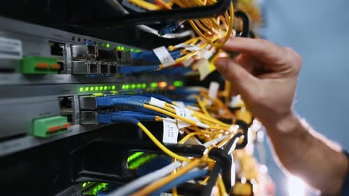 Technician working on a server with fiber optic cables