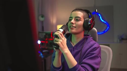A content creator or streamer singing into a microphone while interacting with the computer screen